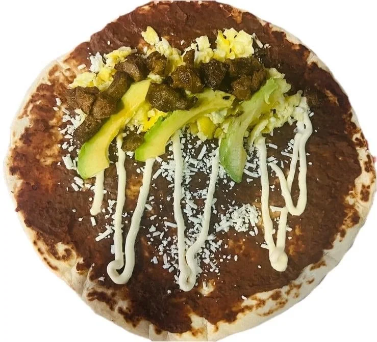 Baleada Con Todo - Traditional Honduran flour tortilla filled with refried beans, cheese, cream, eggs, avocado, and meat.