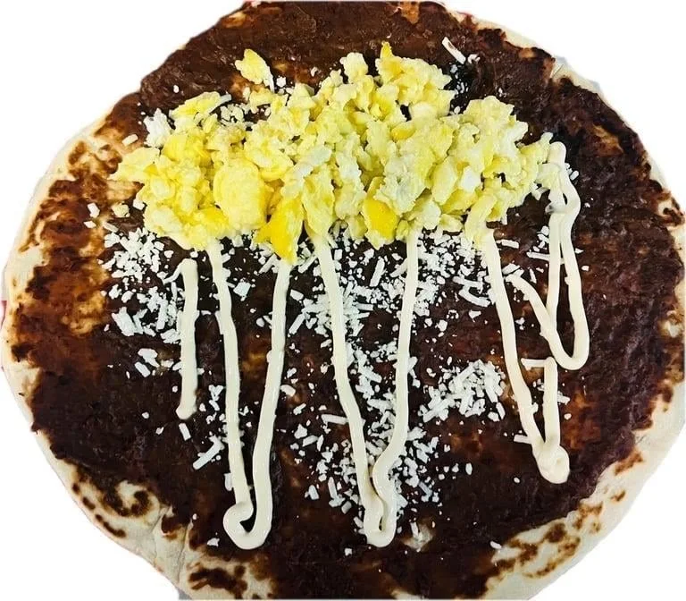 Baleada Sencilla Mas Huevo - Simple baleada with refried beans, cheese, cream, and eggs.